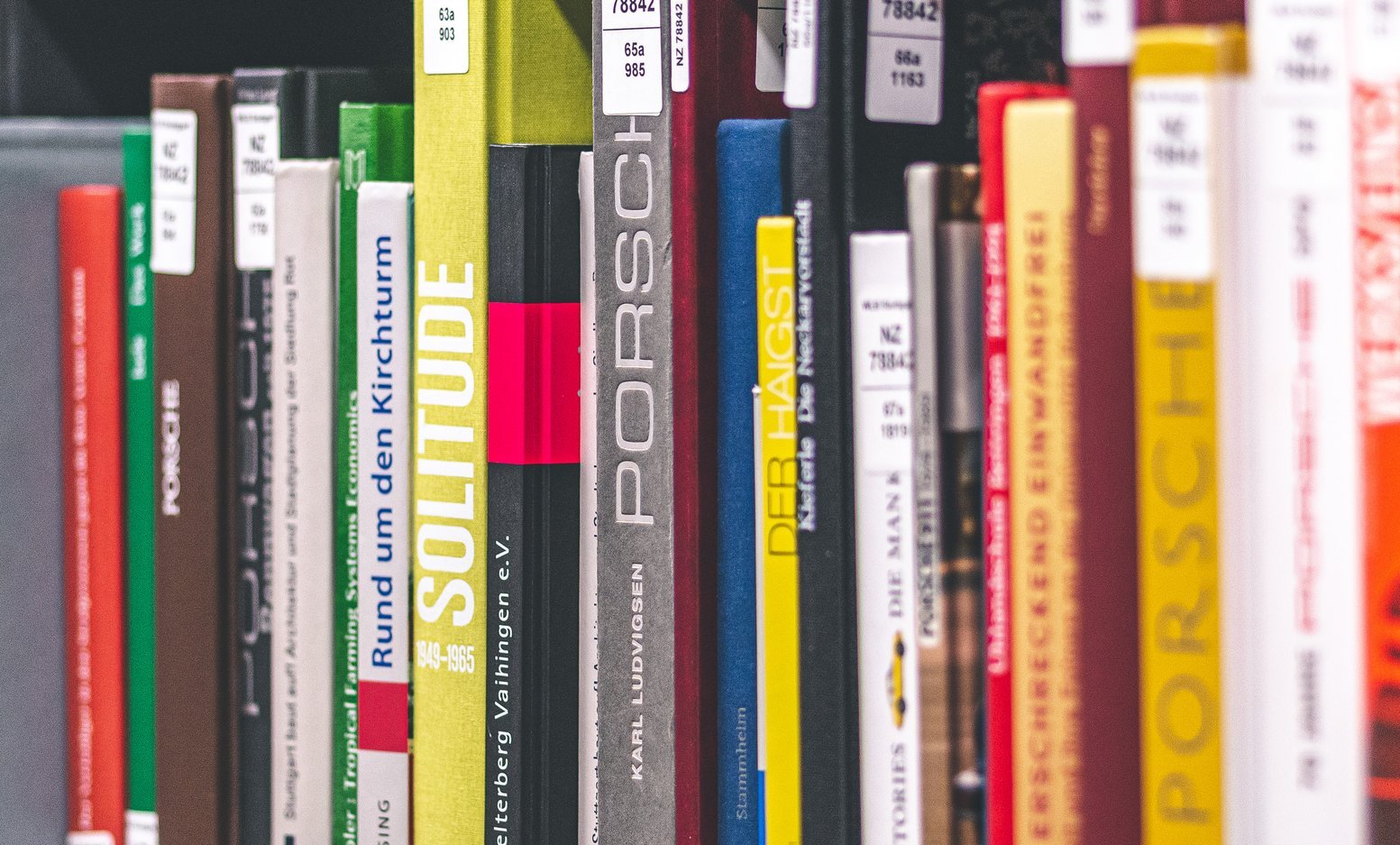 Eine Reihe von bunten Buchrücken, die verschiedene Titel und Autoren zeigen.